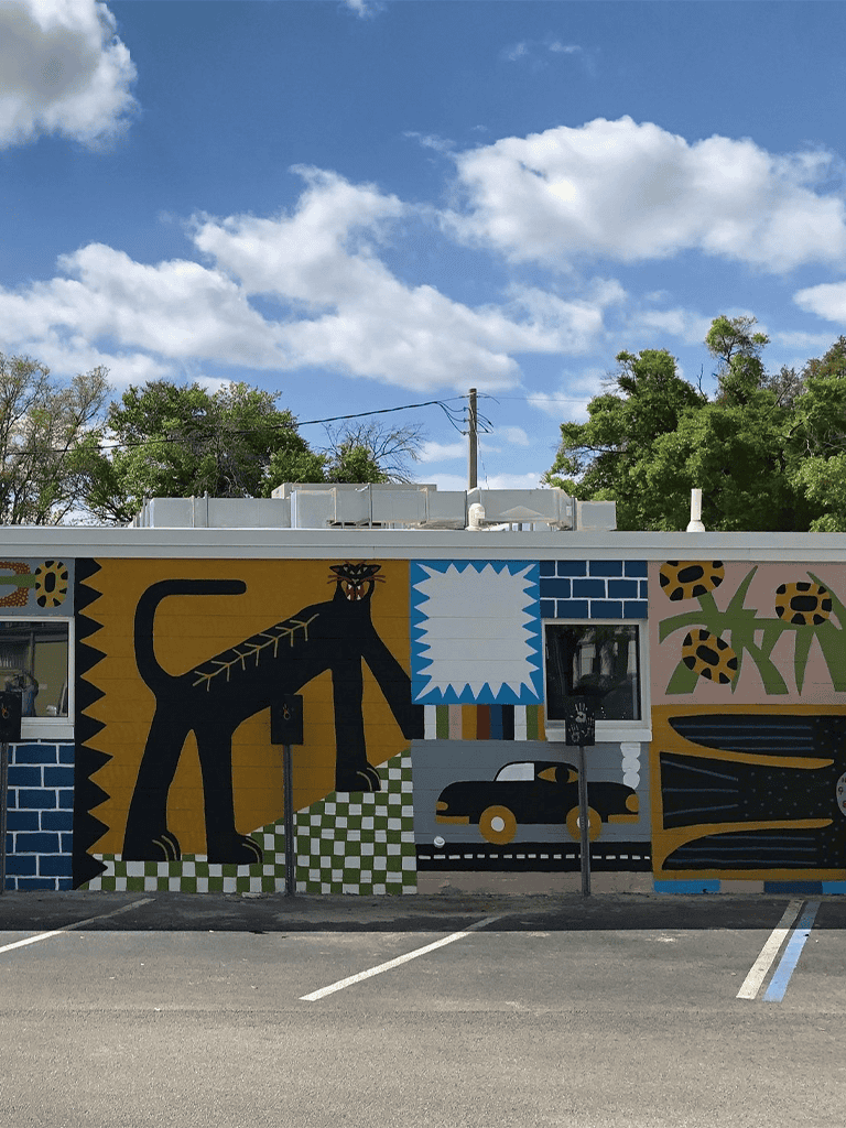 Colorful mural on building wall featuring abstract art and nature motifs.