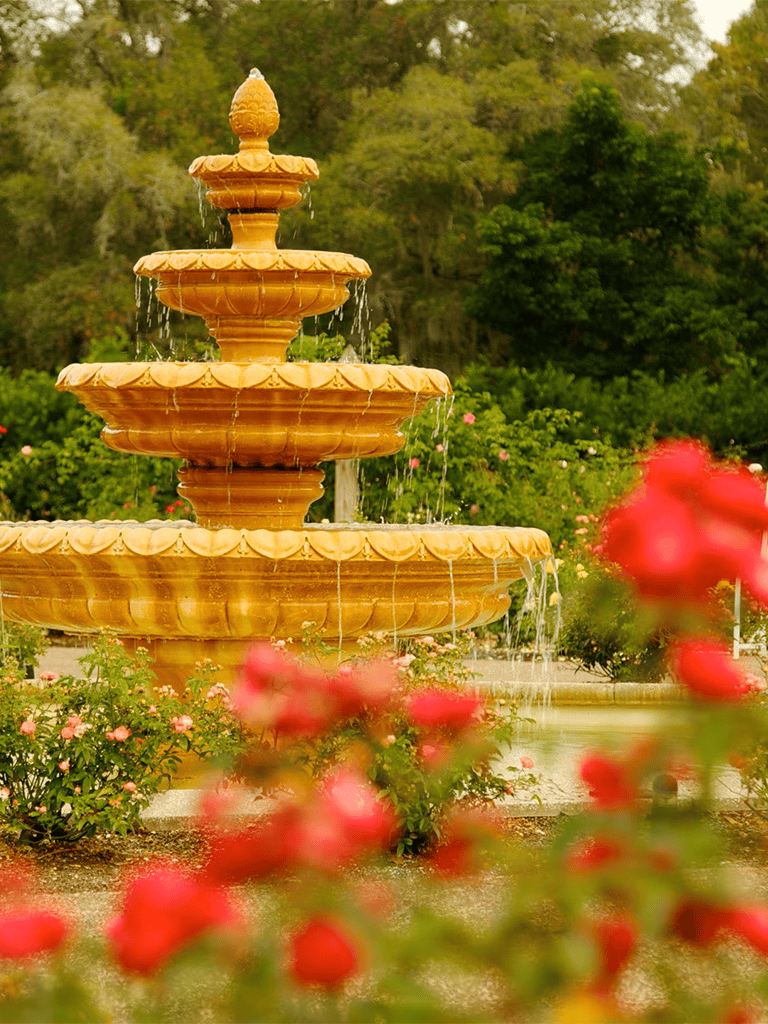 Elegant garden fountain surrounded by colorful flowers, a perfect peaceful outdoor setting, ideal for relaxation and outdoor events.