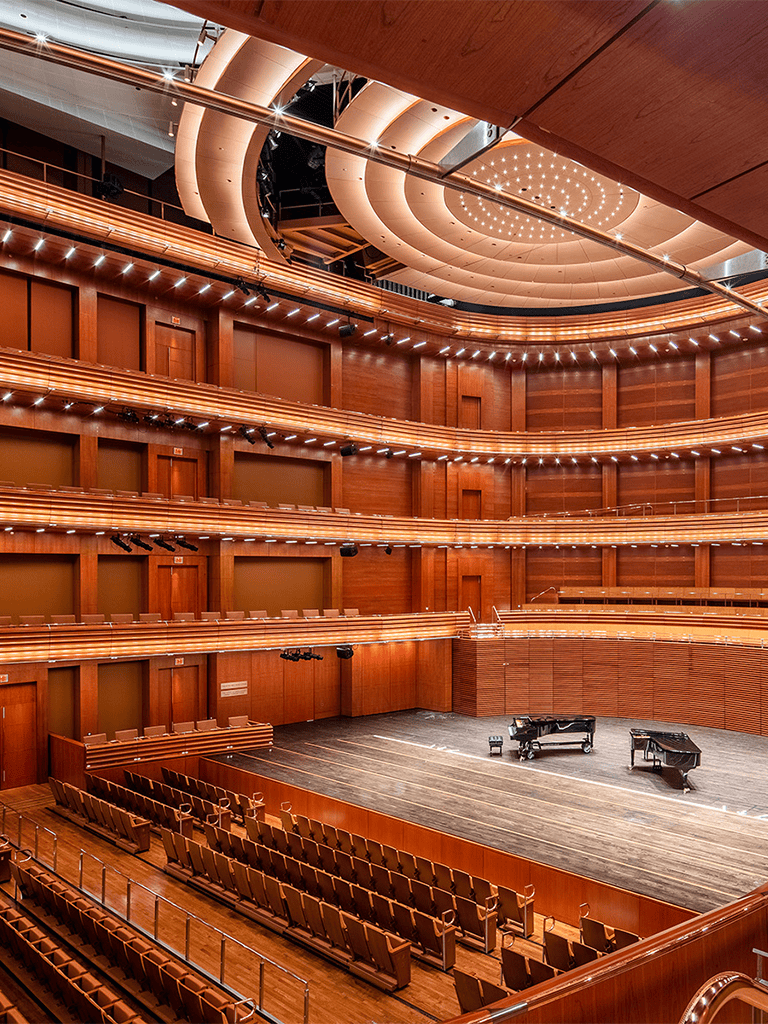 Luxurious concert hall with wooden interior and stage for performances.