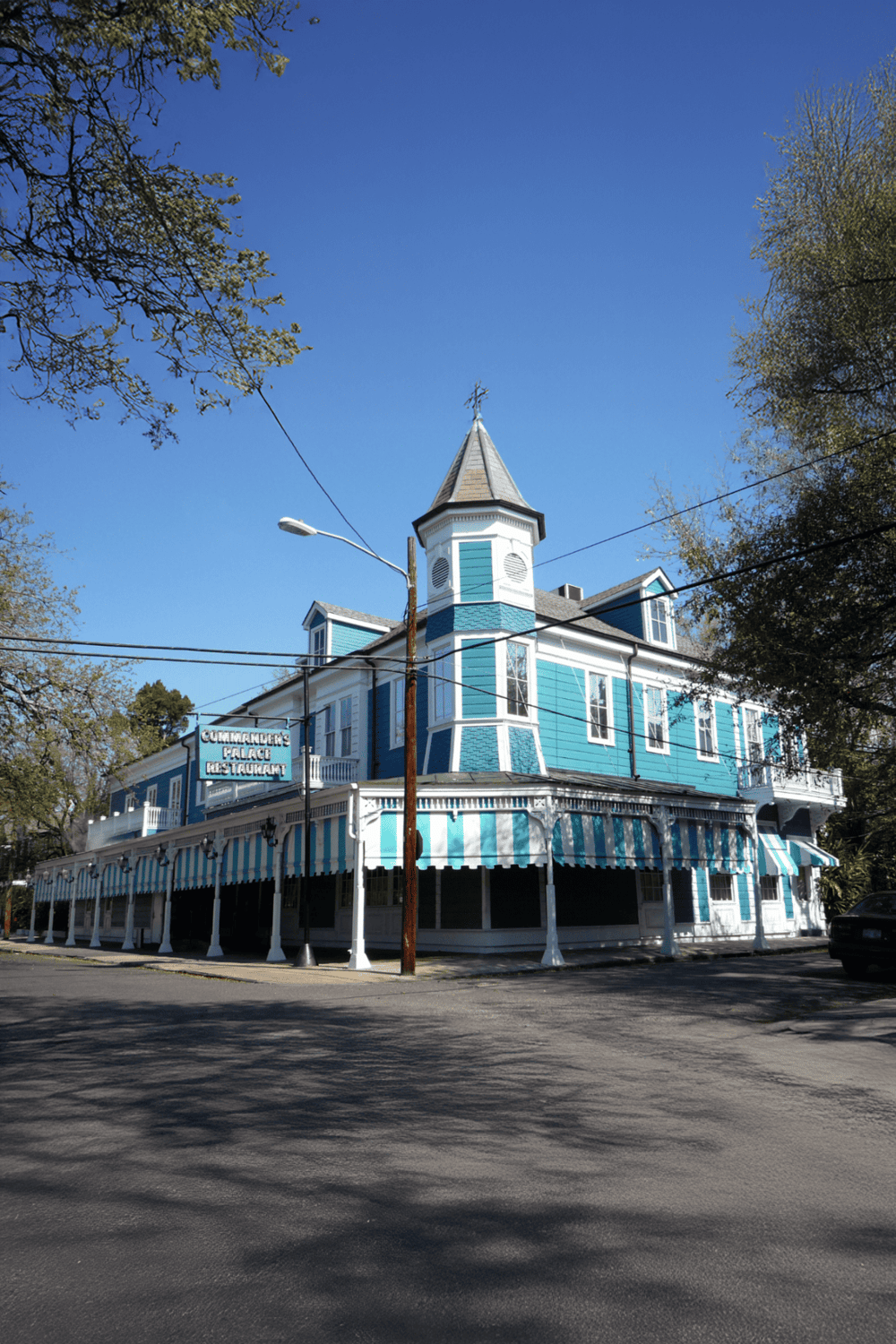 Colorful blue historic building with Victorian architecture, popular restaurant, in a sunny urban setting.