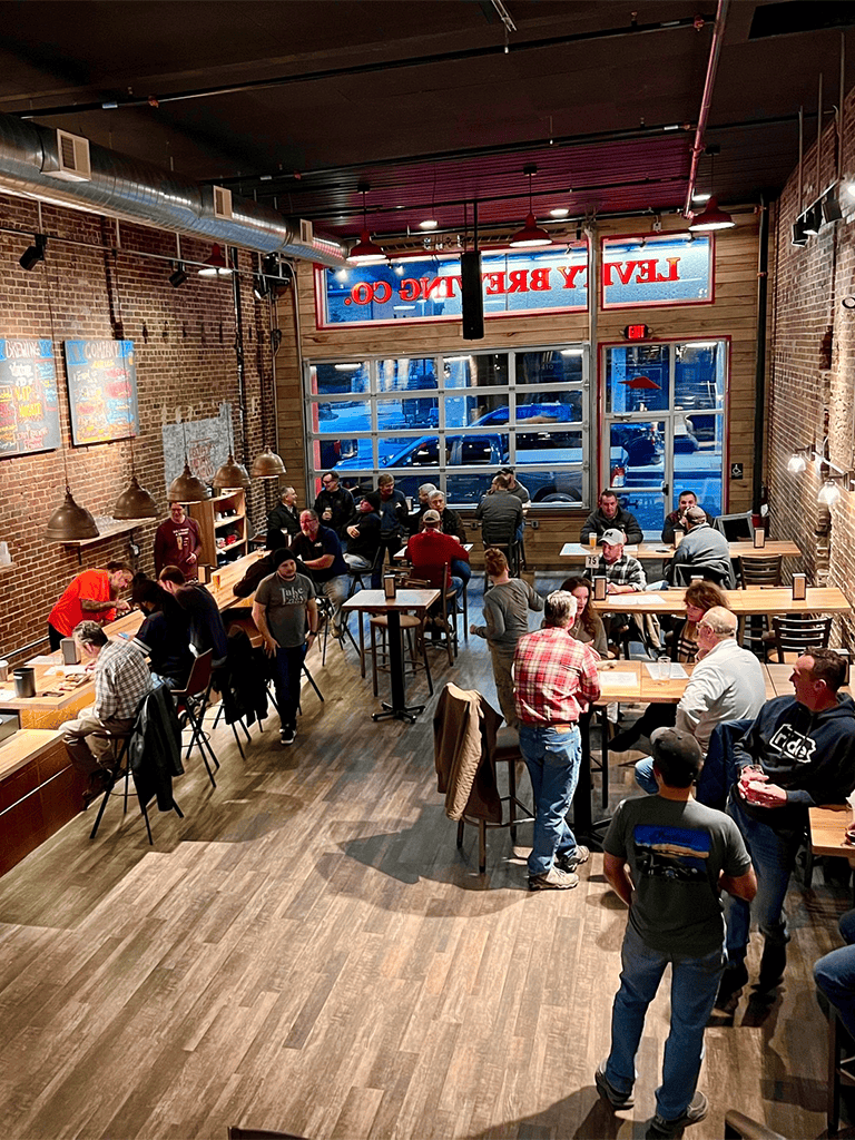 People dining inside a lively restaurant with brick walls and industrial decor.
