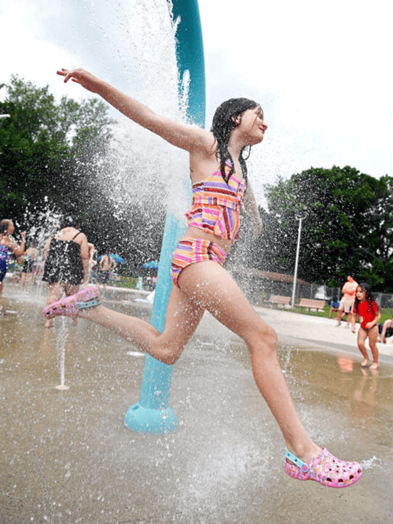 Colorful girl playing at water park on QuestForDirections outdoor fun seating area.