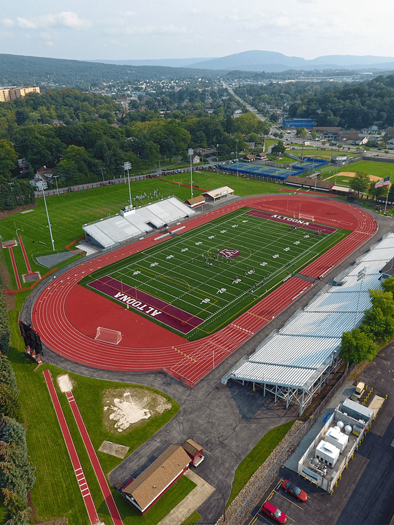 Running track and football field at Al Touna School in a scenic urban area.