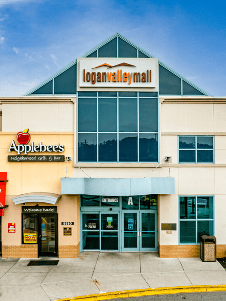 Modern shopping mall entrance with Logan Valley Mall sign and Applebee's restaurant in front.