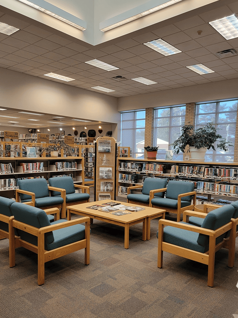 Comfortable library seating area with wooden chairs and bookshelves - Quest for Directions.