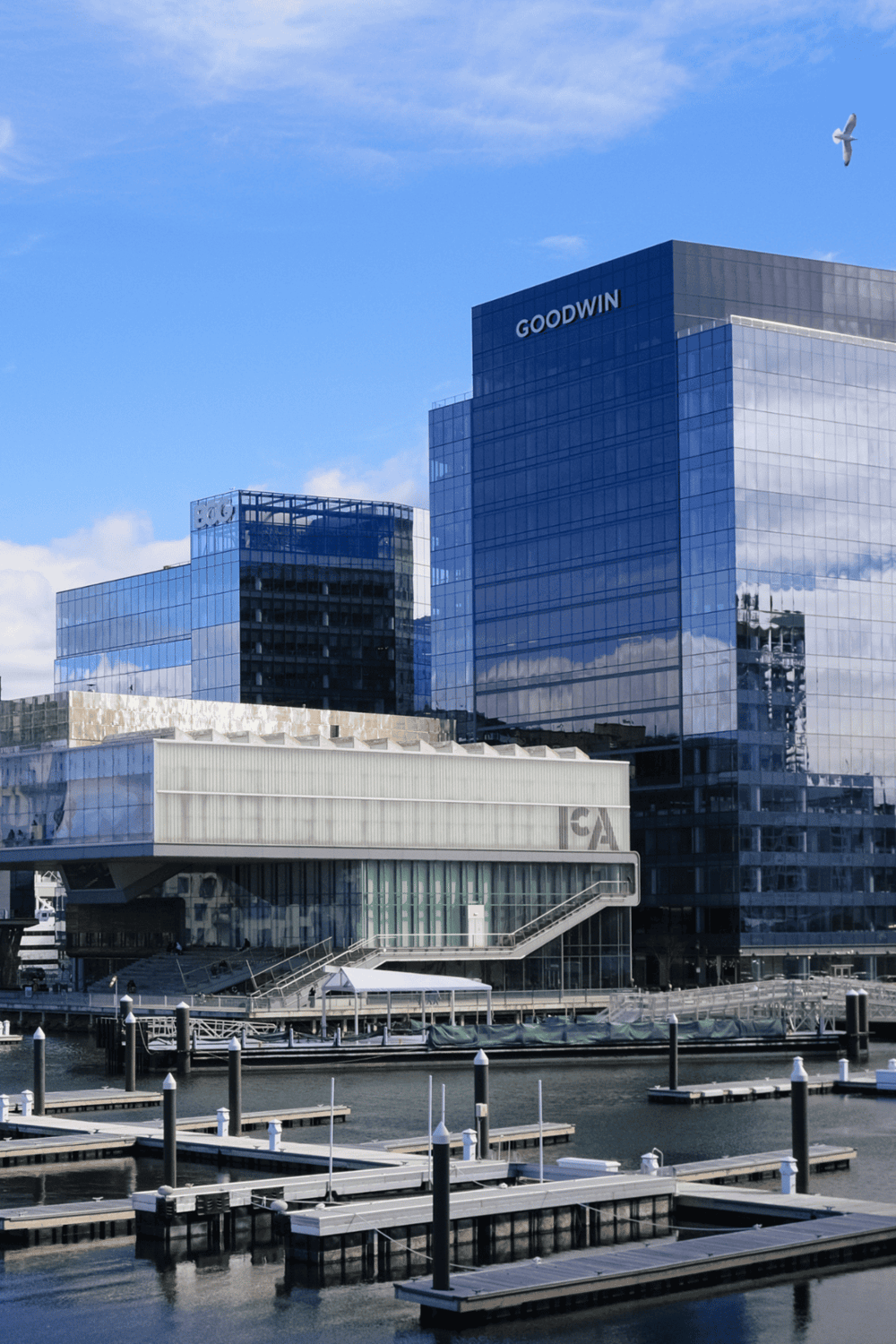 1. Modern downtown building with glass facade and marina in foreground, QuestForDirections.