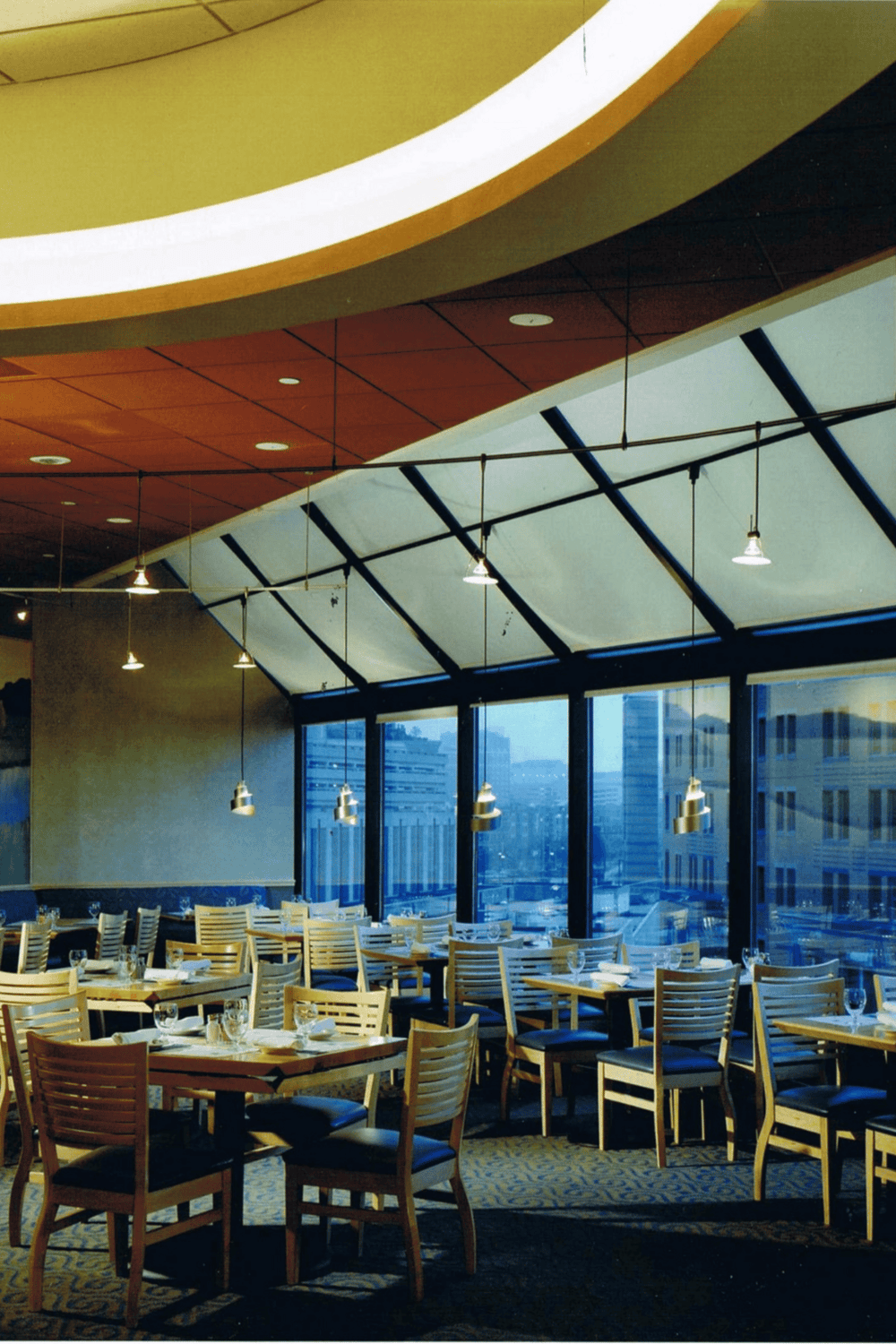 Relaxing modern restaurant interior with large windows and stylish lighting.