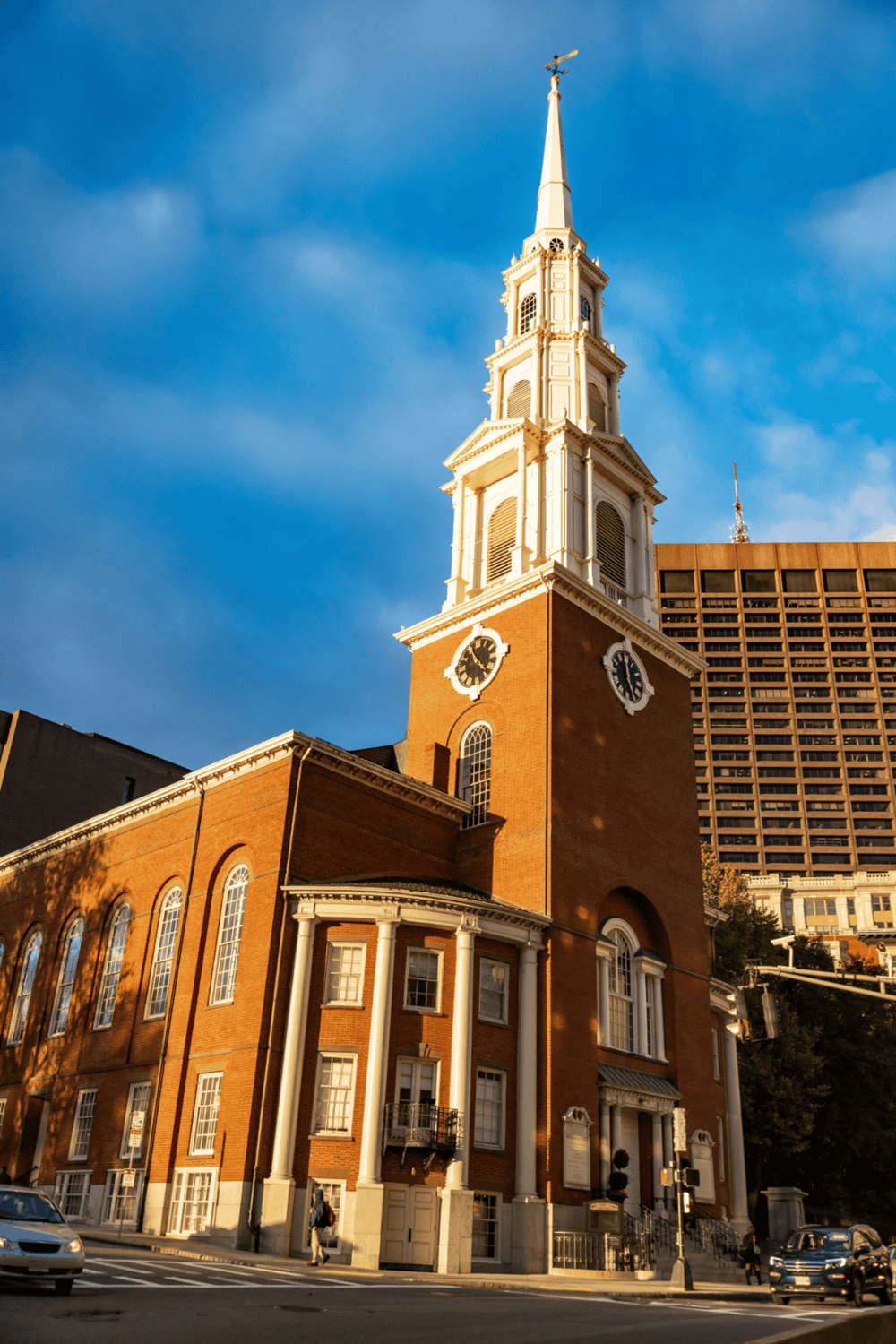 Historic church architecture with clock tower in downtown cityscape.