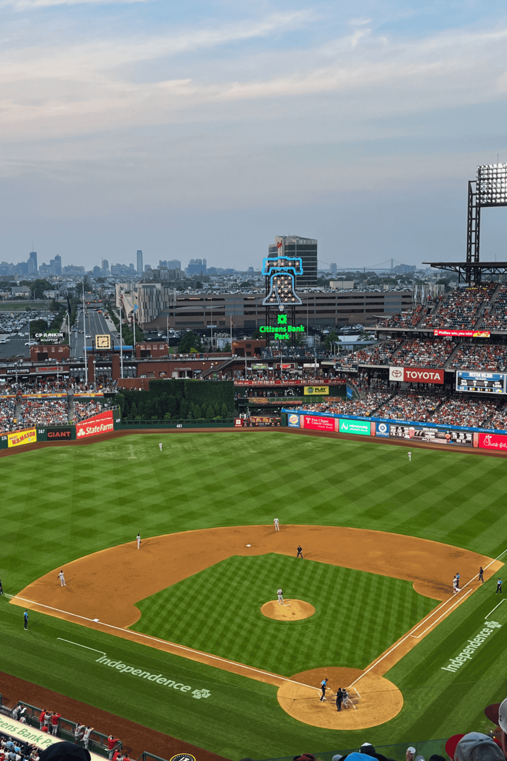 Stylish baseball stadium with city skyline, crowd, and digital scoreboard.