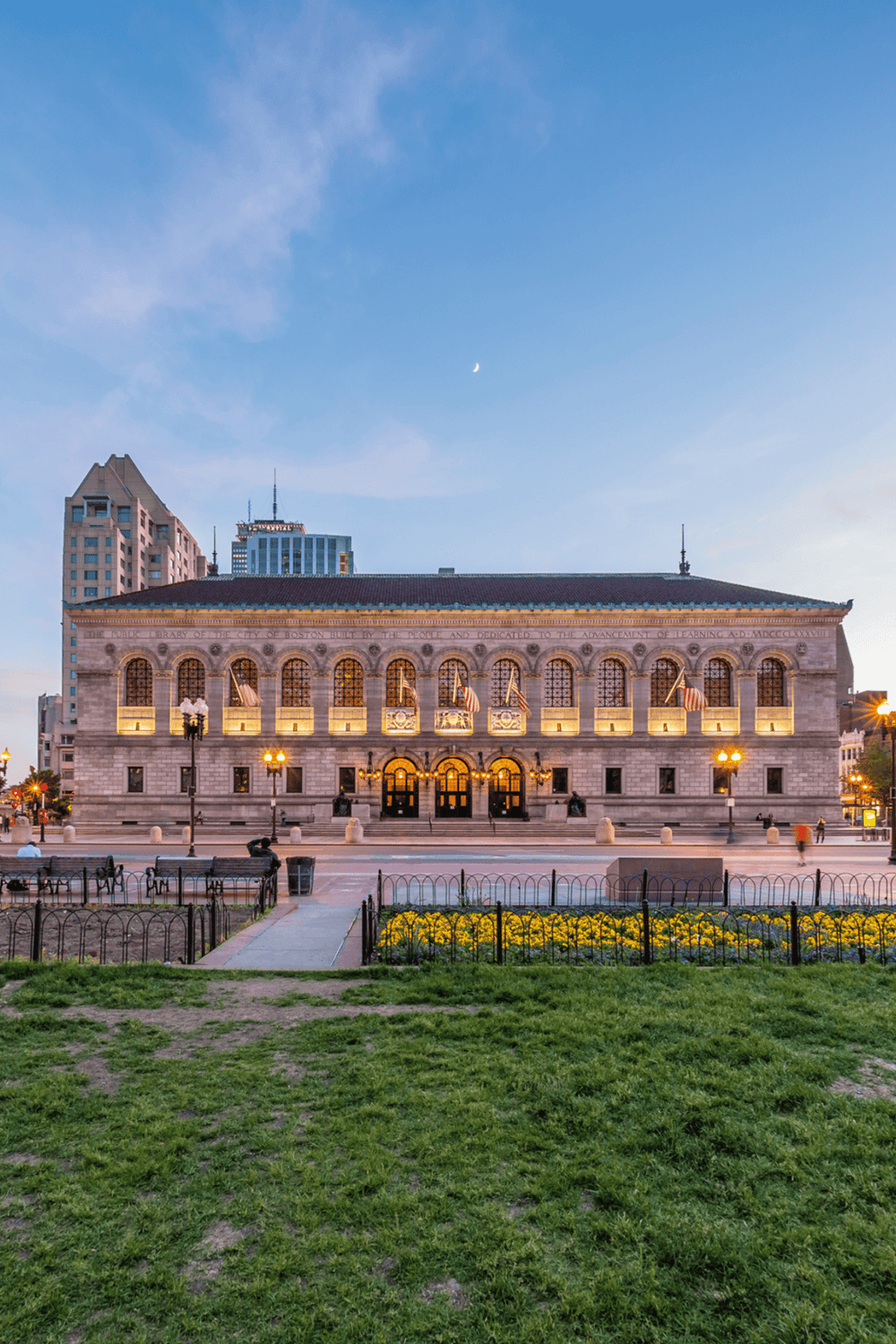 Historic Boston Public Library building at dusk, showcasing beautiful architecture and city skyline.