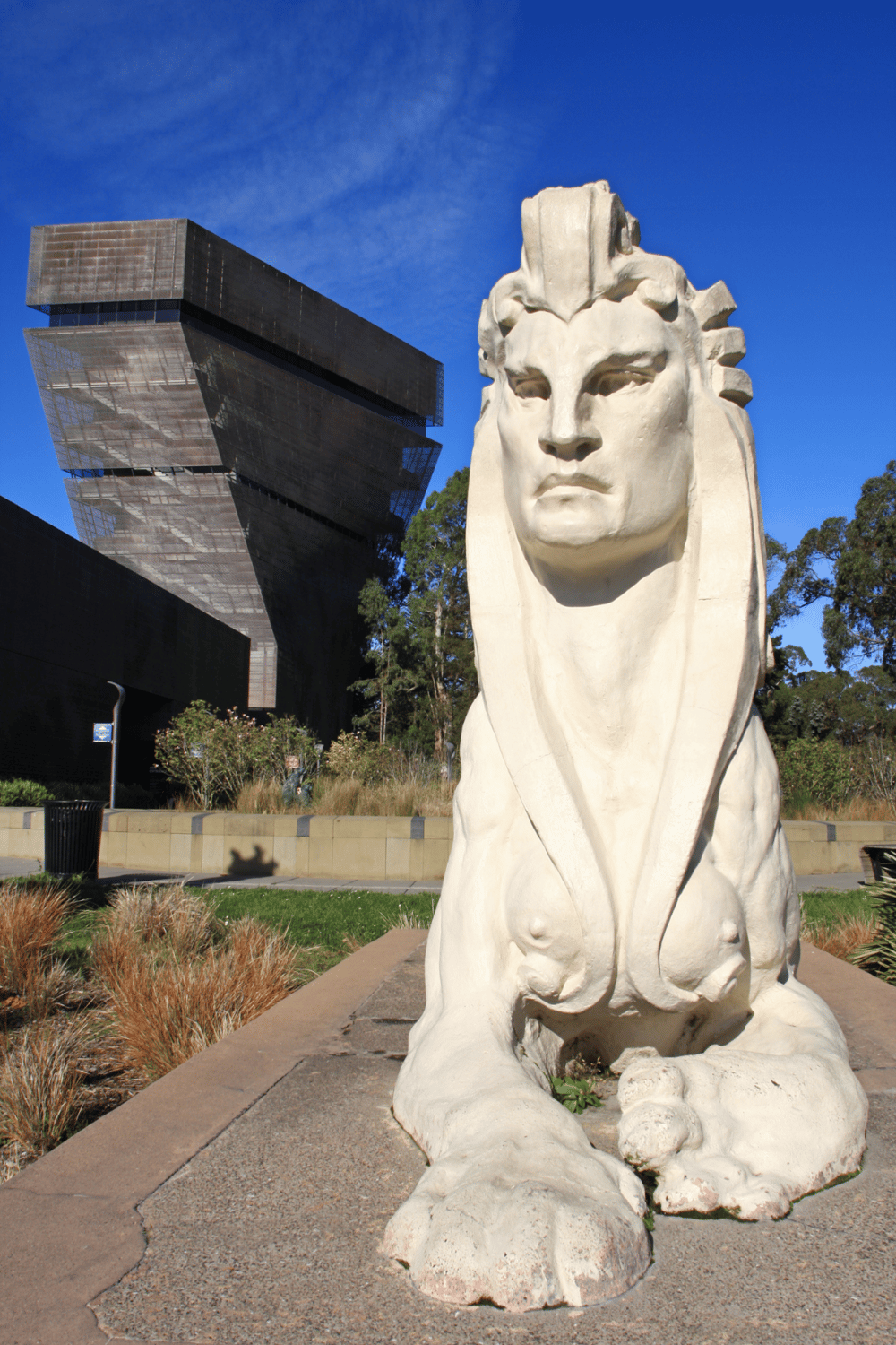 Modern art sculpture of a lion with a contemporary building in the background, representing architecture and public space.