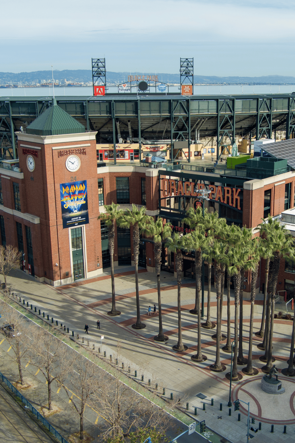 Vibrant Oakland Athletics ballpark entrance with towering palm trees and downtown skyline.