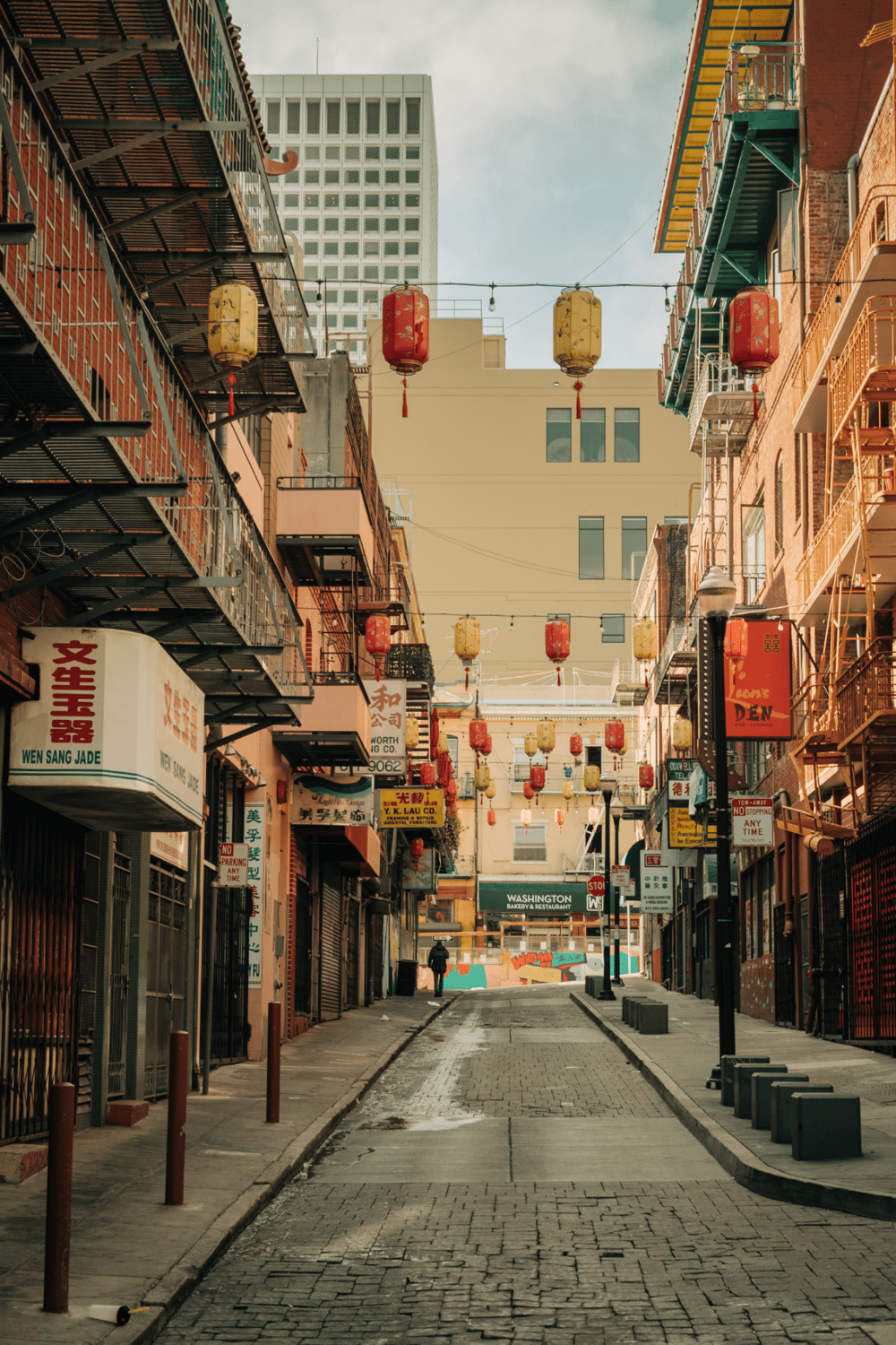 Colorful Chinatown street with hanging lanterns and vibrant storefronts, perfect for exploring Asian cuisine and culture.