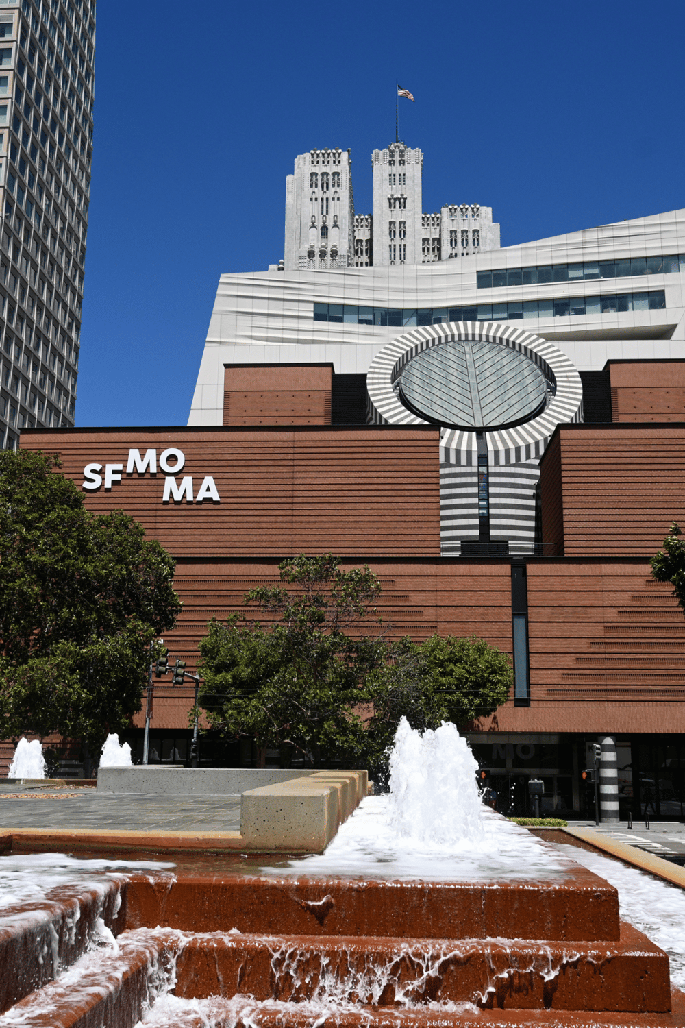 Modern San Francisco Museum of Modern Art (SFMOMA) building with fountains and city skyline, a top tourist attraction in San Francisco.