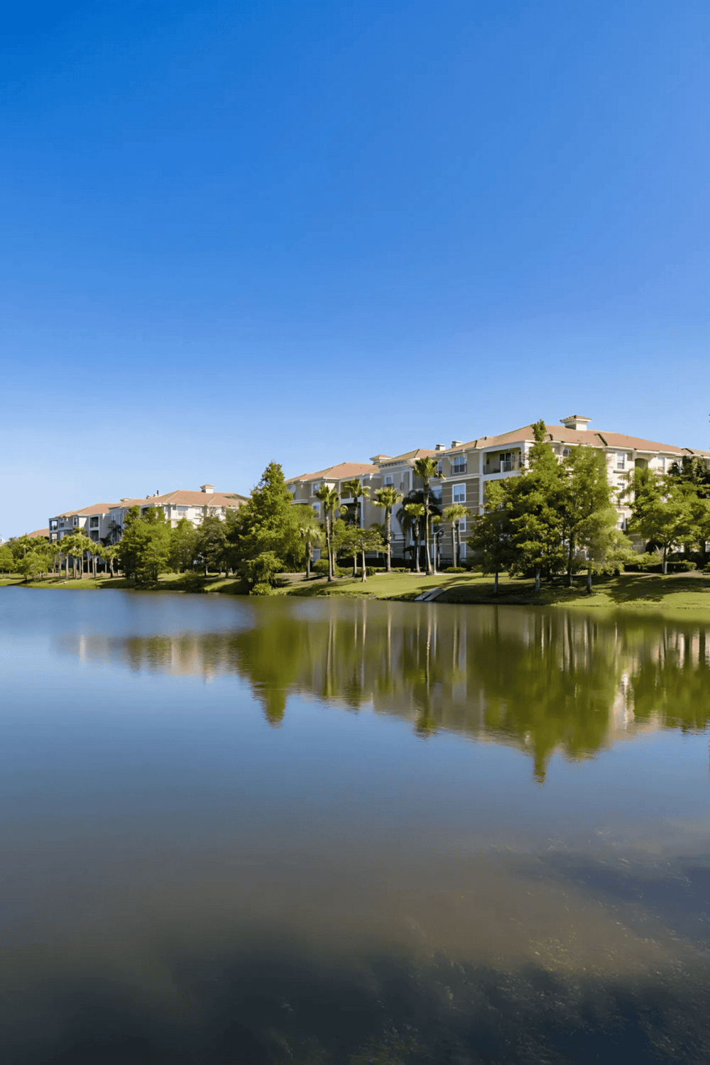 Luxurious lakeside apartment community with lush landscaping and scenic water views.