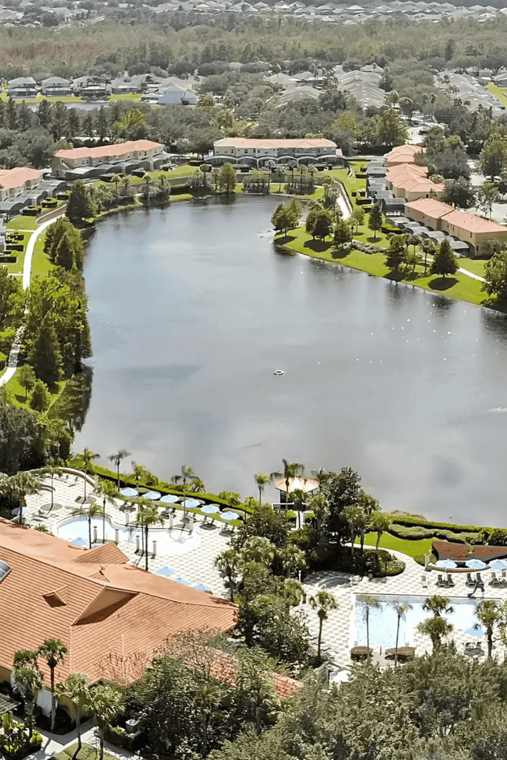 Serene lakeside community with lush greenery, modern homes, and recreational amenities, perfect for peaceful living.