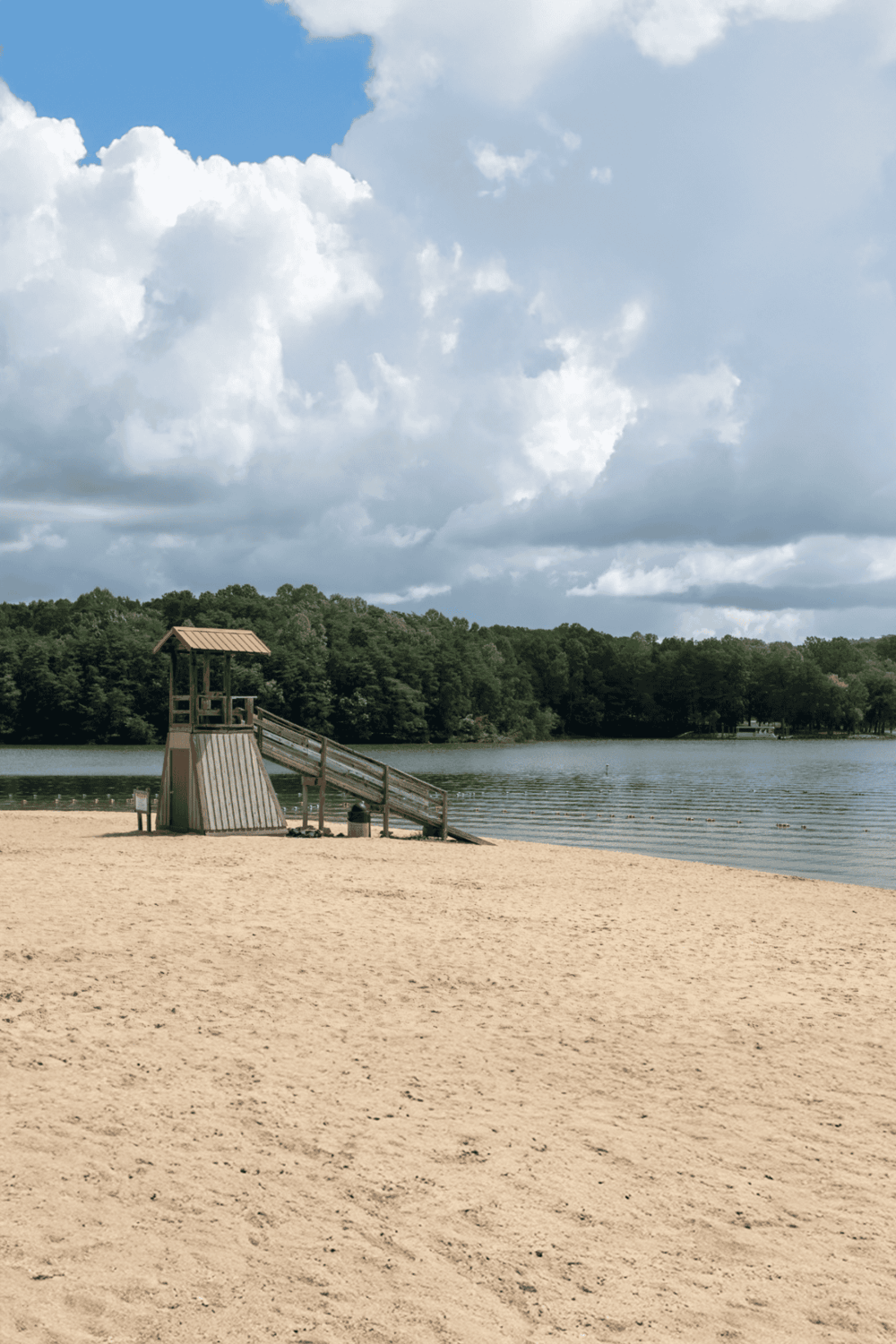 Seaside beach with lifeguard tower and calm water, perfect for relaxation and outdoor activities.