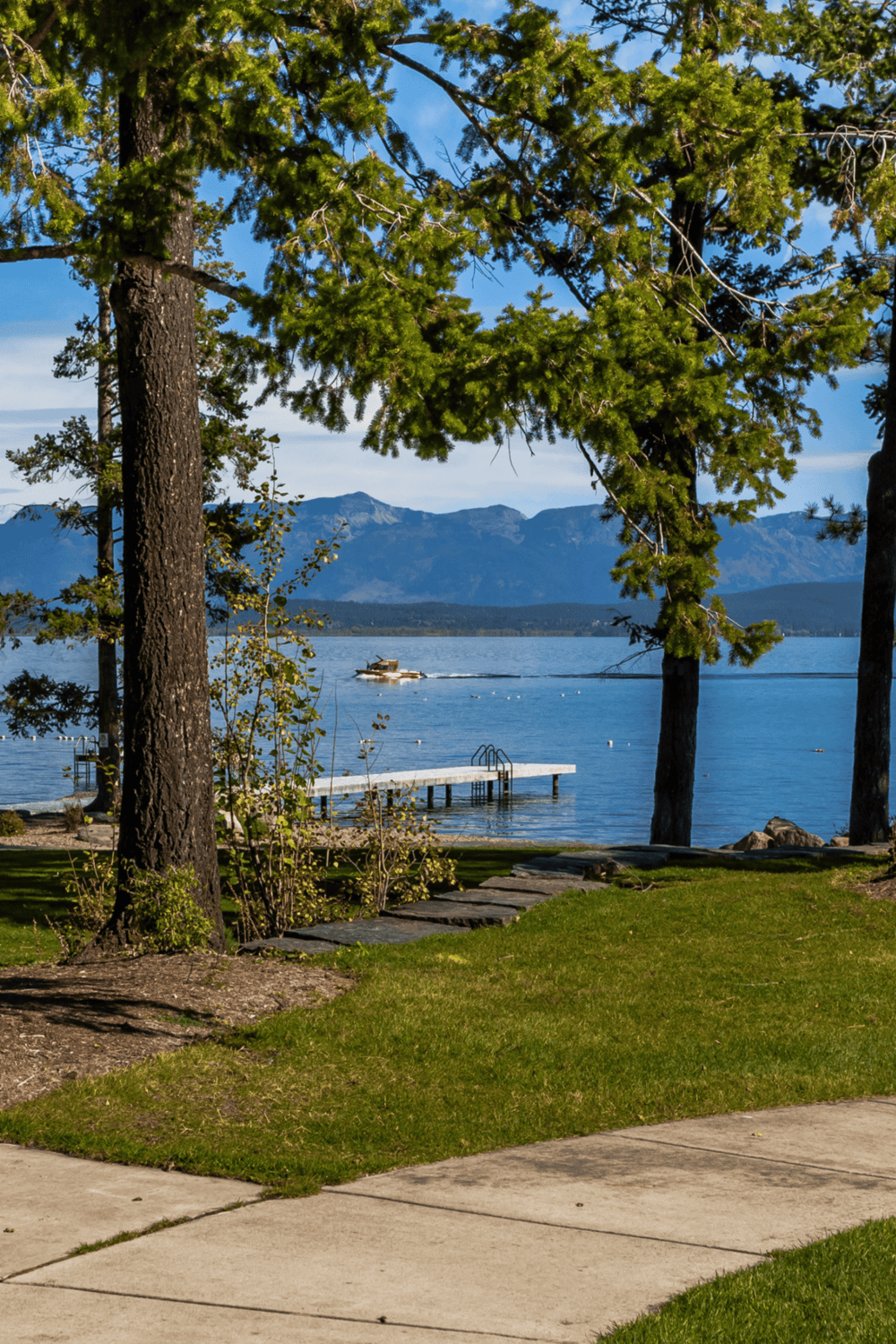 Relaxing lakeside view with trees, mountains, and dock at QuestForDirections.