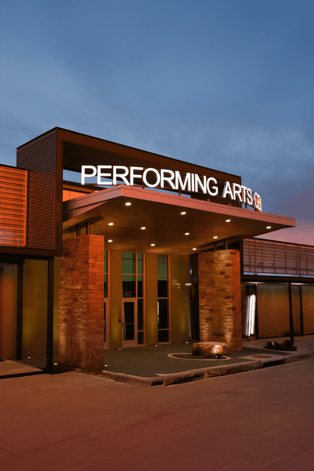 Performing arts center with illuminated signage at dusk, showcasing modern architecture and entertainment venue.