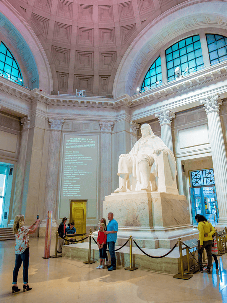 Statue of Abraham Lincoln in the Lincoln Memorial, Washington D.C., with visitors exploring the site.