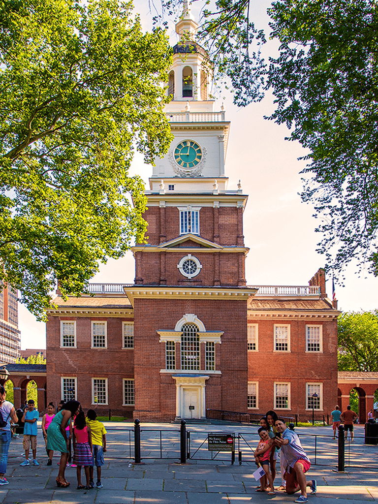 Historic downtown Philadelphia city hall with children playing and tourists, iconic American landmark, popular travel destination, QuestForDirections.