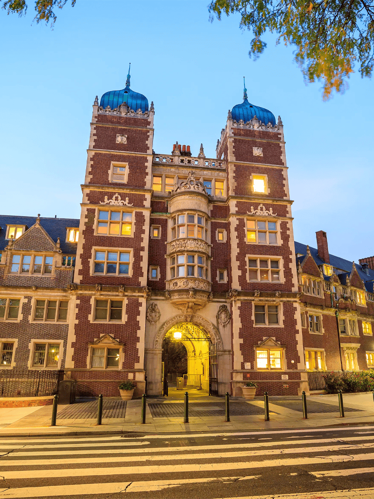 Elegant historic castle with ornate architecture and blue domed towers, illuminated at dusk in The Hague, Netherlands.