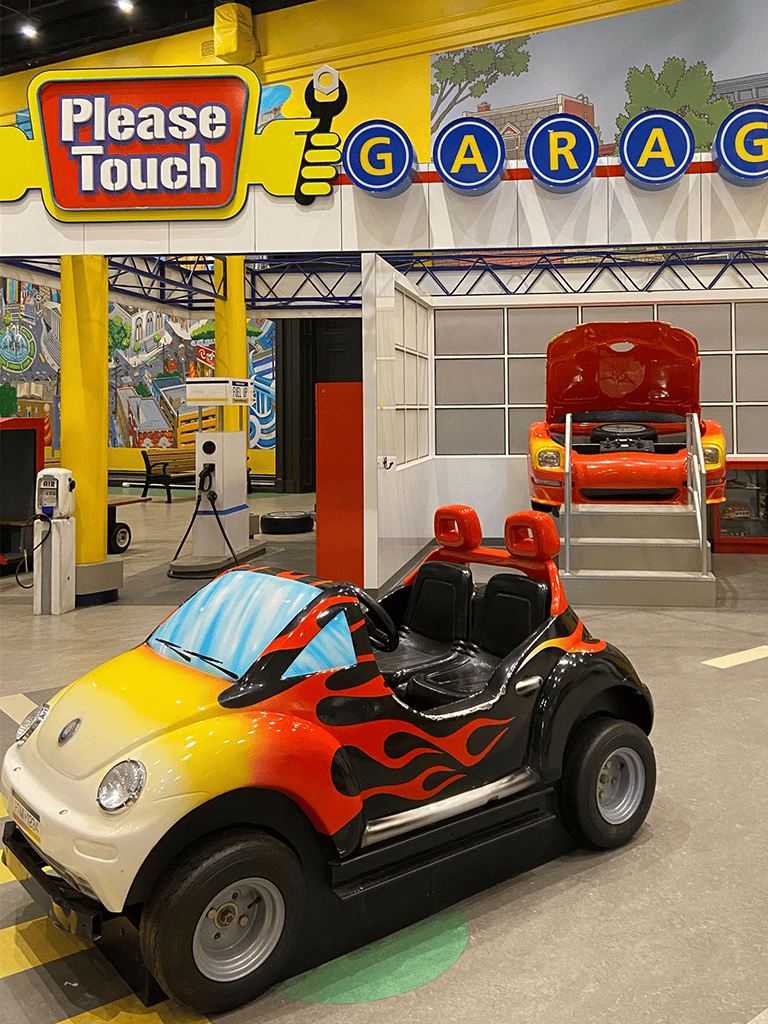 Colorful kids' go-kart ride at QuestForDirections indoor playground in a vibrant family entertainment center.
