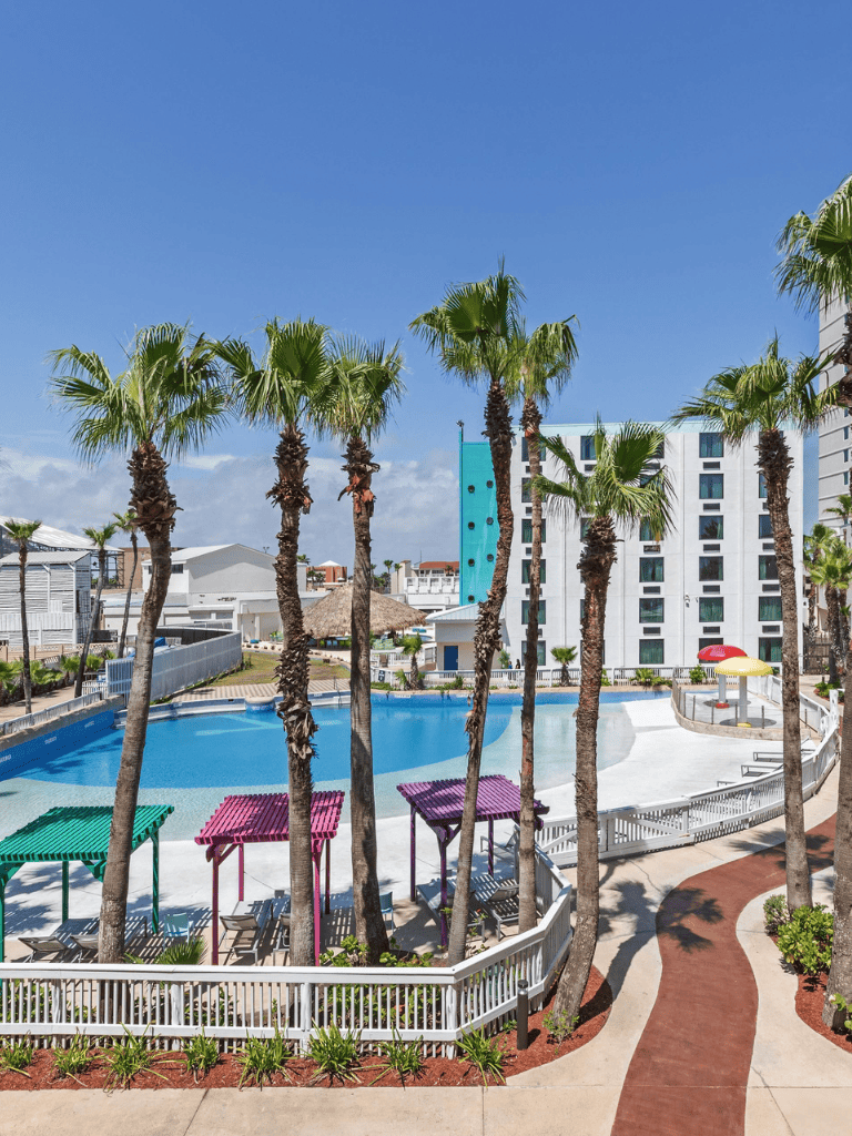 Palm trees surrounding a colorful pool area at Quest For Directions resort.