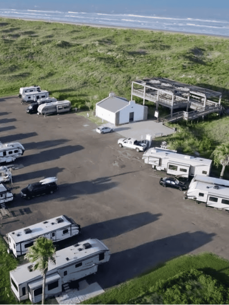 Beachside RV parking lot with trailers and vehicles, overlooking the ocean, scenic and convenient for travelers.