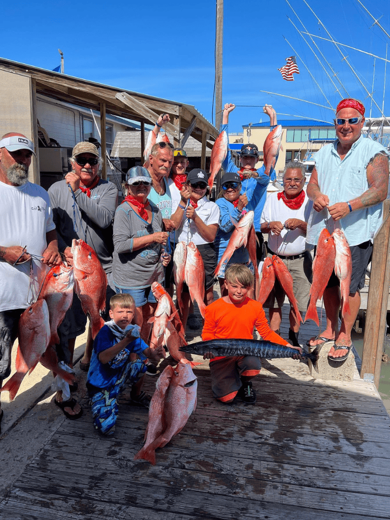 Vibrant group of anglers with freshly caught fish at dockside, showcasing successful fishing adventure.