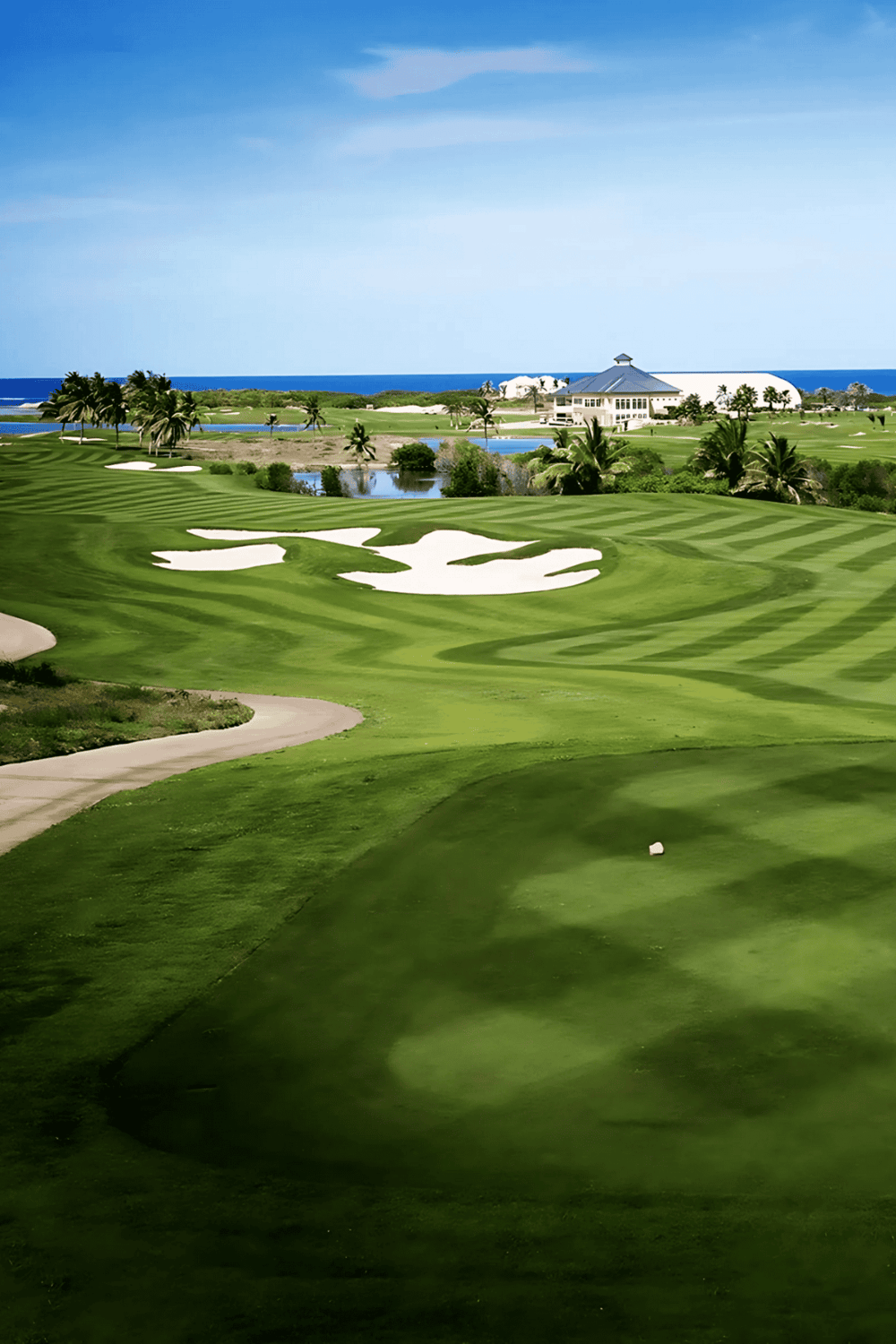 Beautiful golf course with ocean view, lush greenery, and sand traps for outdoor recreation.