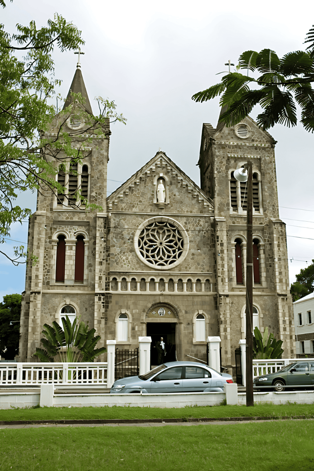 Stone church with twin bell towers and rose window, historic religious landmark.