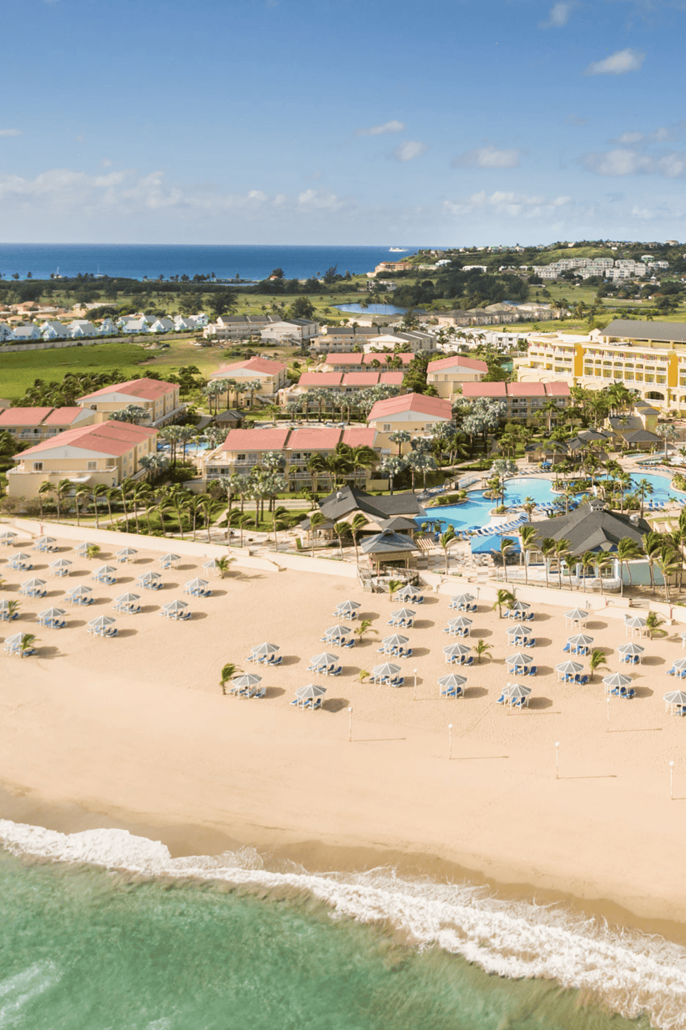 Luxurious beach resort with swimming pools, ocean view, and sandy shoreline perfect for relaxation.