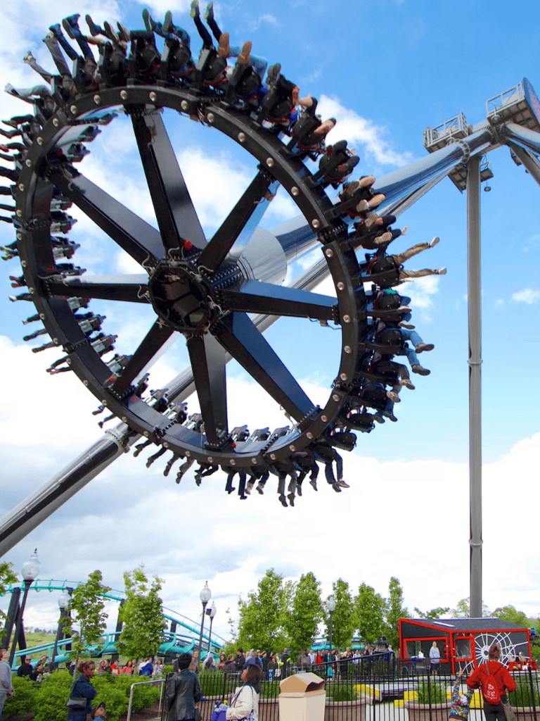 Thrilling roller coaster ride at an amusement park during daytime with visitors enjoying the fun.