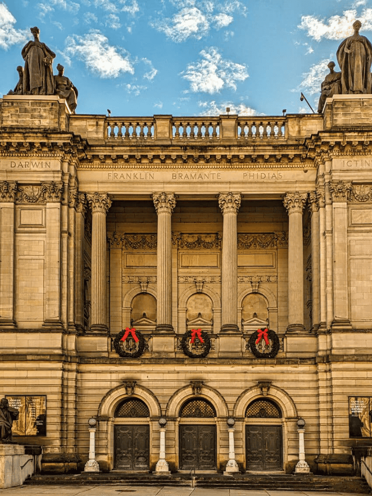 Imposing historic building with classical architecture and festive wreath decorations.