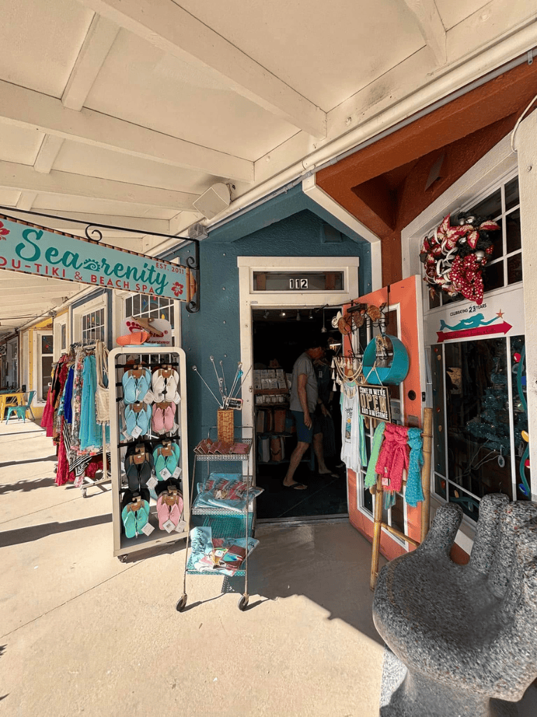 Colorful beach shop entrance in a seaside shopping district, offering sandals and souvenirs.