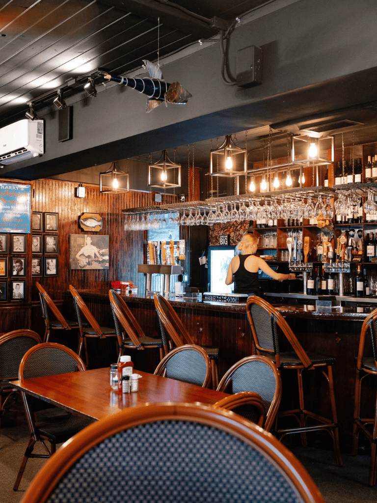 Cozy bar interior with wooden decor and elegant lighting, perfect for relaxed social gatherings and drinks.