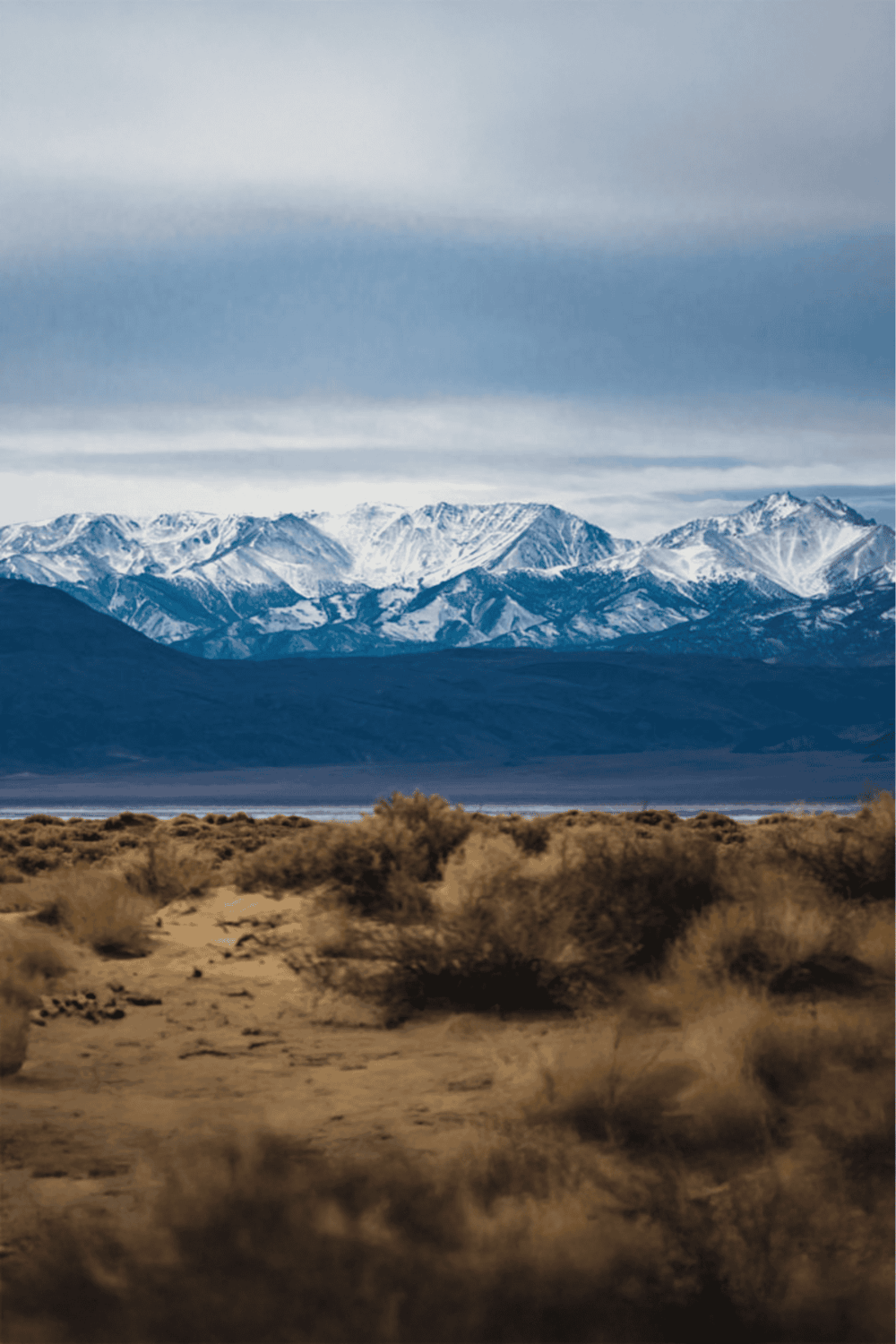 Snow-capped mountains with desert landscape in foreground, scenic exploration, adventure travel, QuestForDirections.