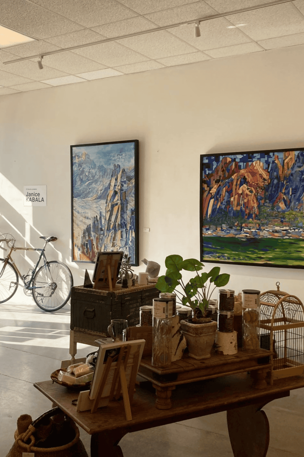 Art gallery interior showcasing vibrant landscape paintings and eco-friendly decor, Ideal for art enthusiasts and interior design inspiration.