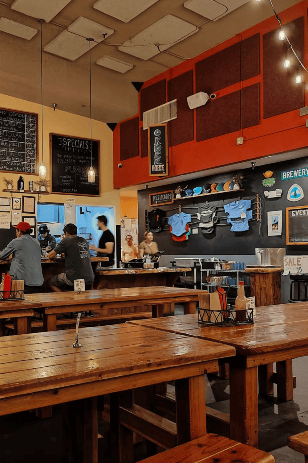 Cozy brewery interior with wooden tables, bar seating, and vibrant decor, perfect for craft beer enthusiasts.