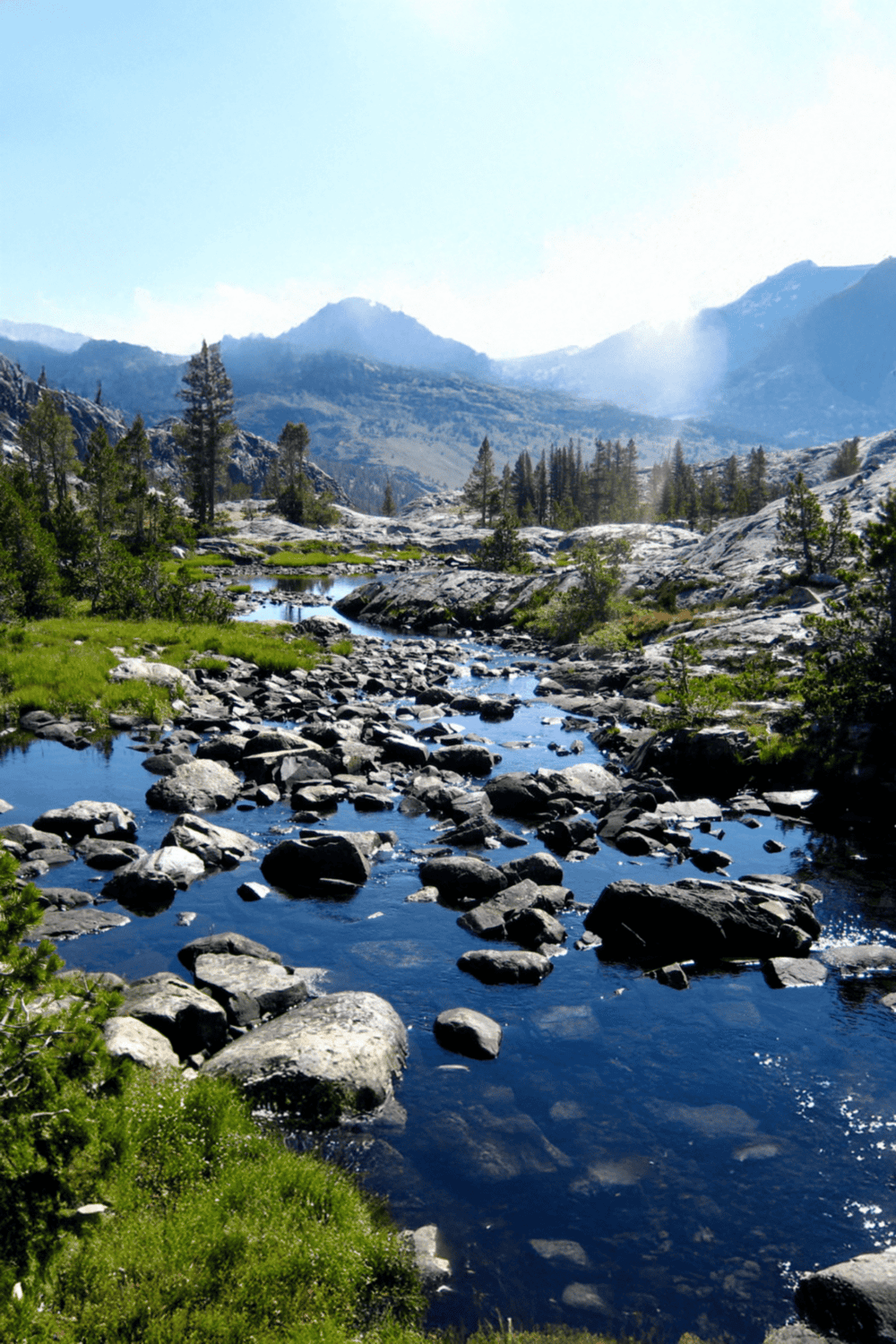 Snowy mountain landscape with river and pine trees, perfect for outdoor adventure and scenic nature exploration.