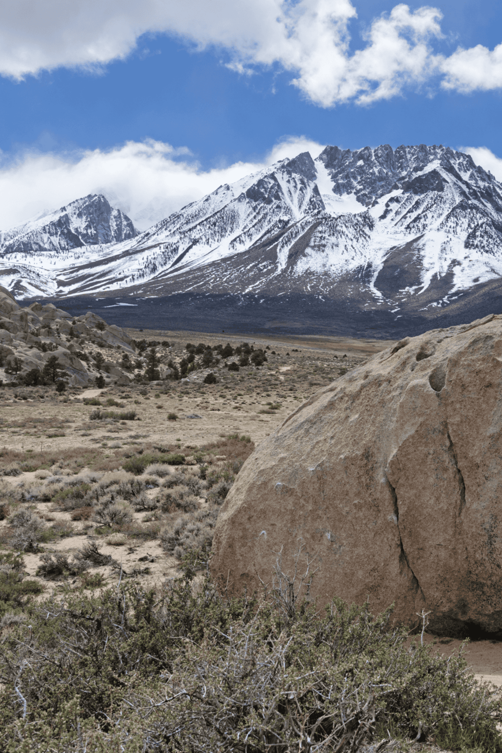 Snow-capped mountain landscape in California with rocky desert terrain and sparse vegetation.