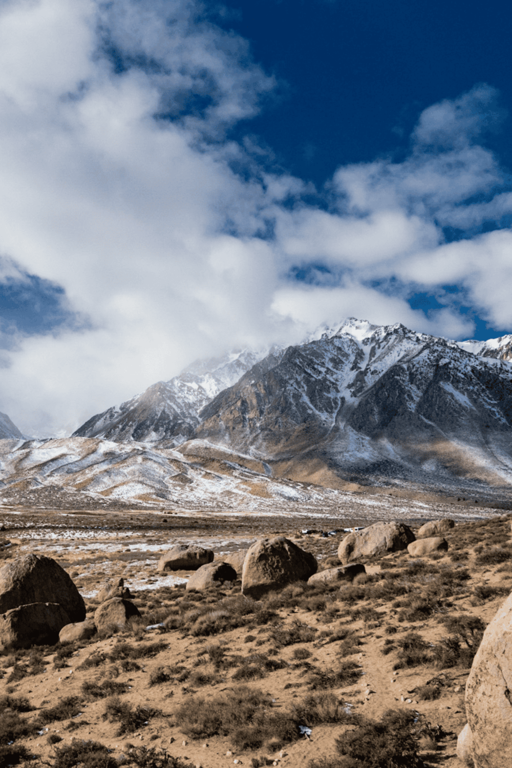 Snow-capped mountain landscape with rocky terrain and blue sky, ideal for outdoor adventure and travel directions.
