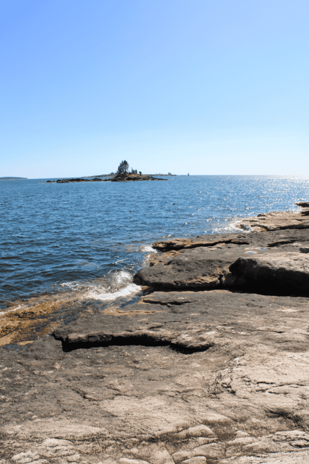 Serene coastal landscape with rocky shoreline and ocean view, perfect for navigation and adventure planning.