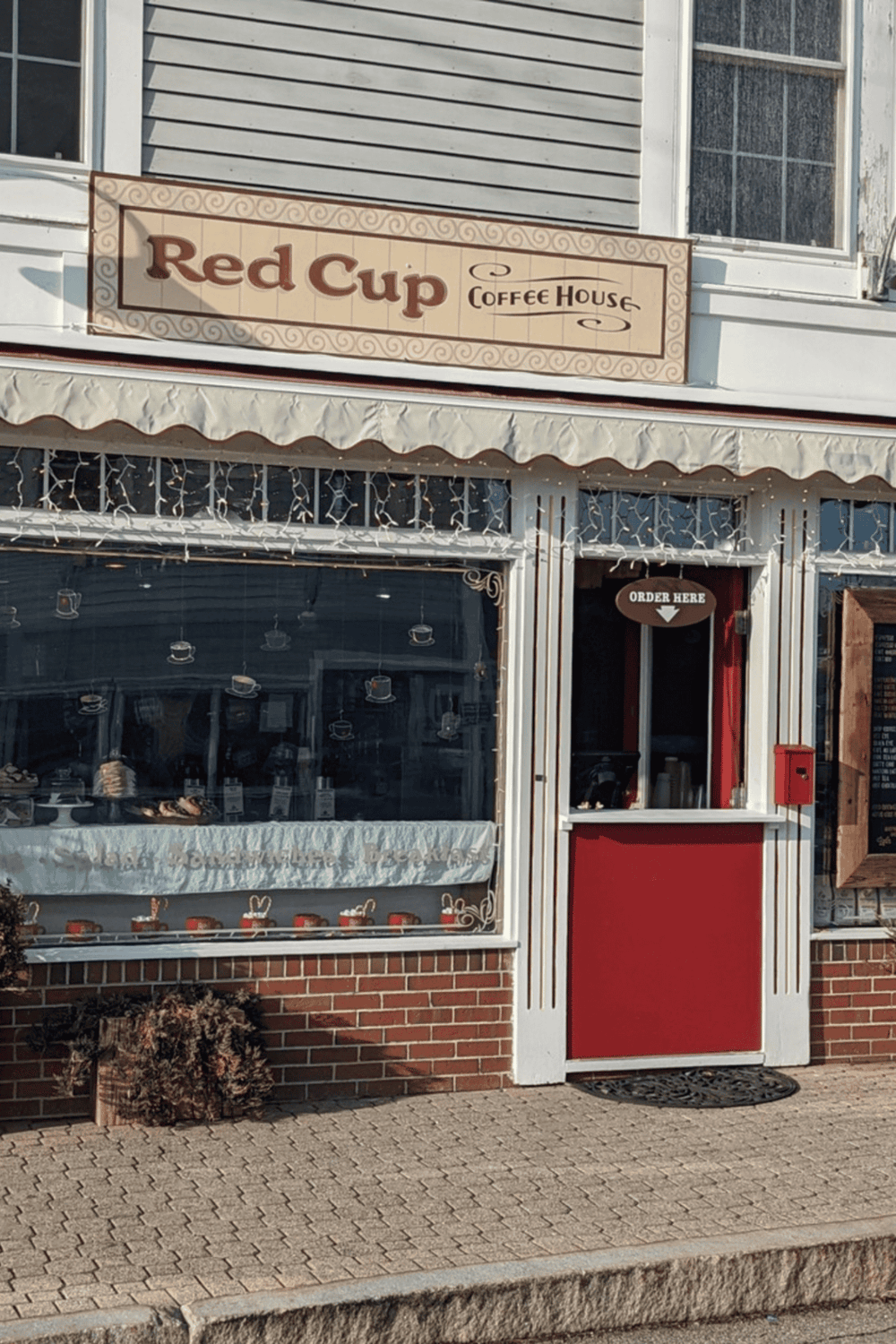 1. Cozy coffee shop exterior with "Red Cup Coffee House" sign and curbside order window.