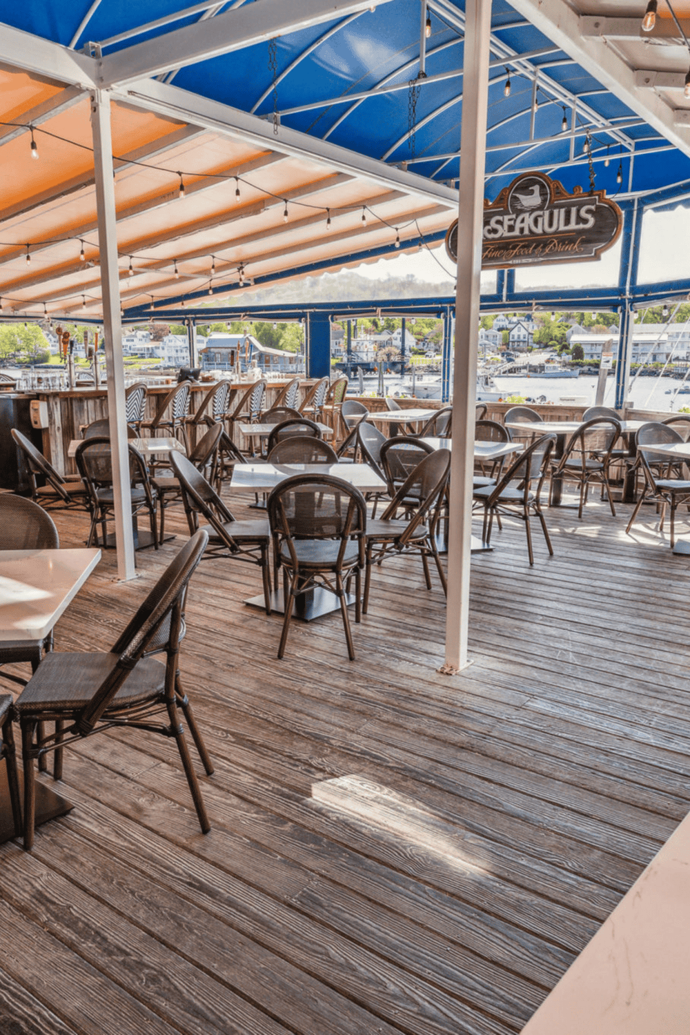 Outdoor waterfront dining at Seagulls restaurant with nautical decor and scenic marina views.