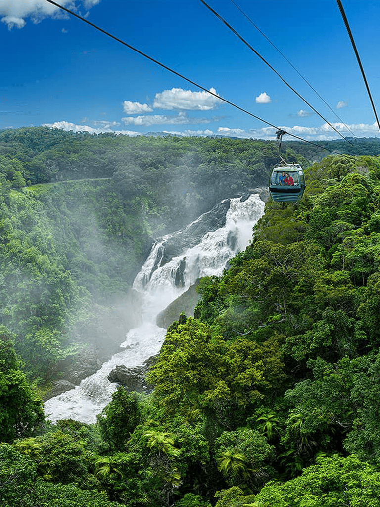 Vibrant waterfall and lush green rainforest with cable car ride in tropical landscape, nature adventure.