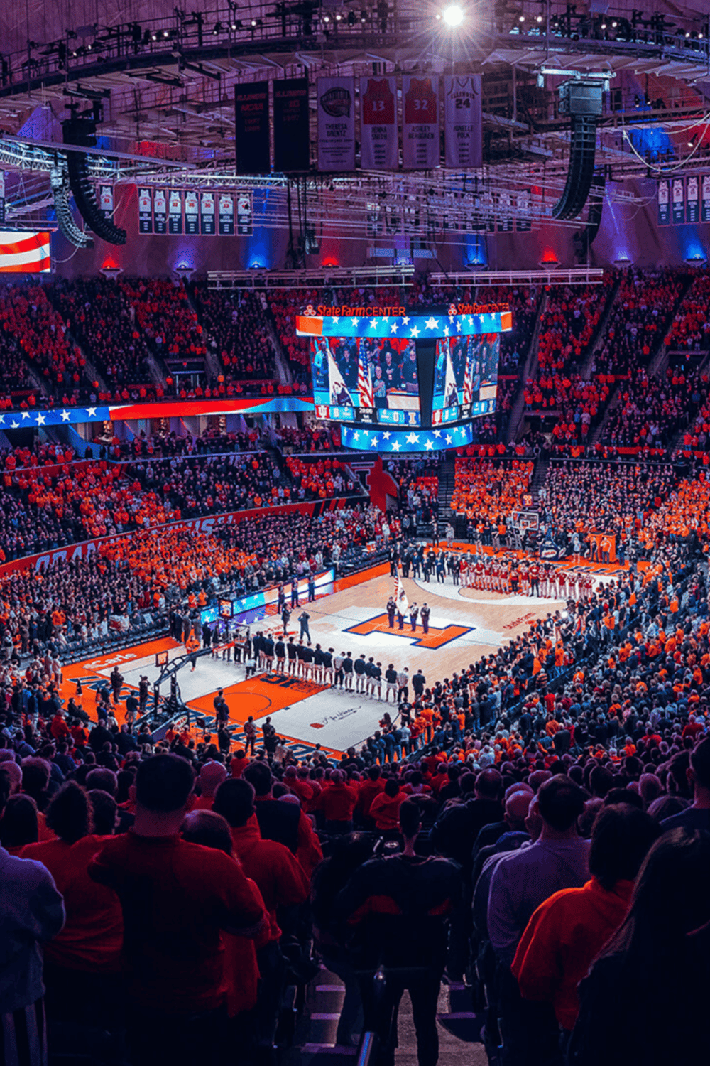 Basketball game at State Farm Center with packed crowd and vibrant red, white, and blue decorations.