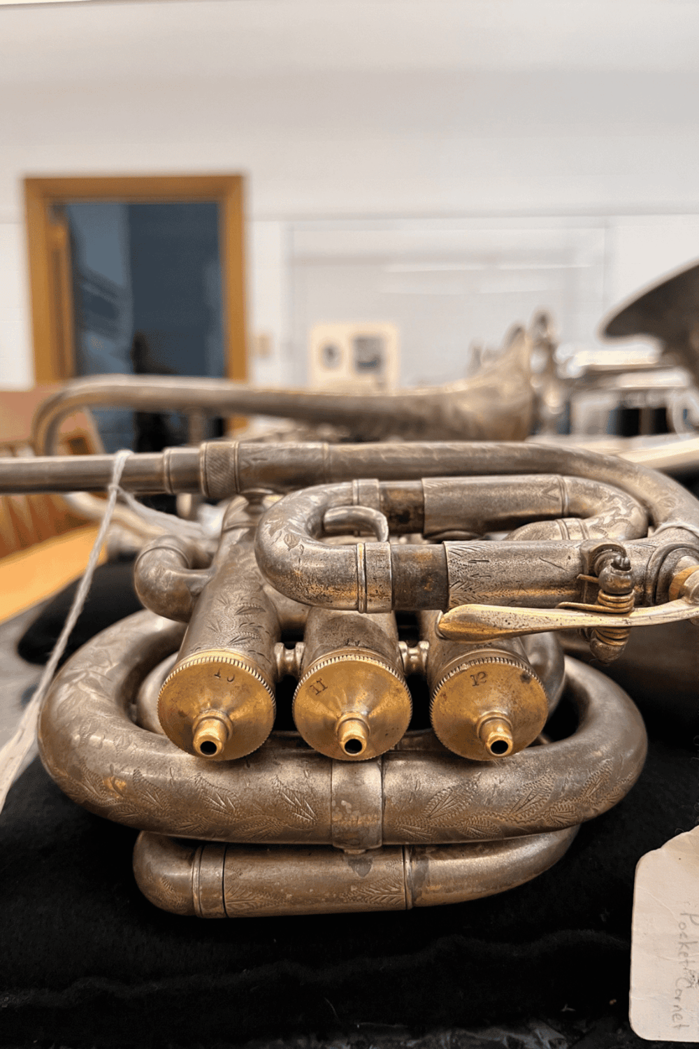 Vintage silver trumpet with engraved details and gold-colored valves.