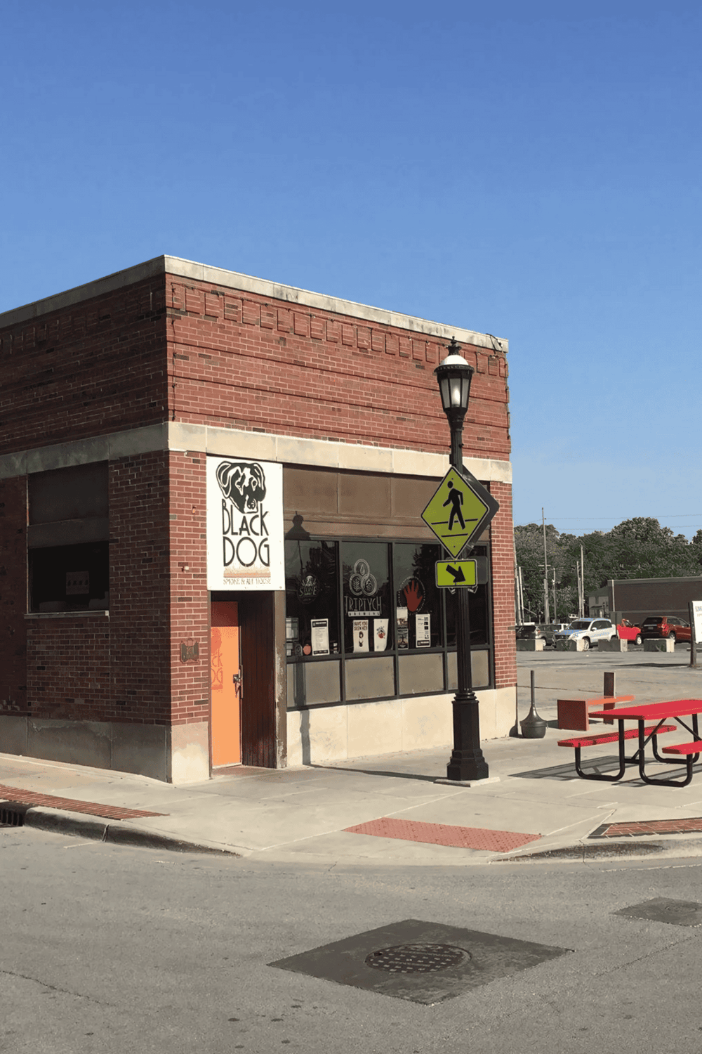 1. Corner of a brick building with Black Dog Smoke Shop sign and pedestrian crossing sign.